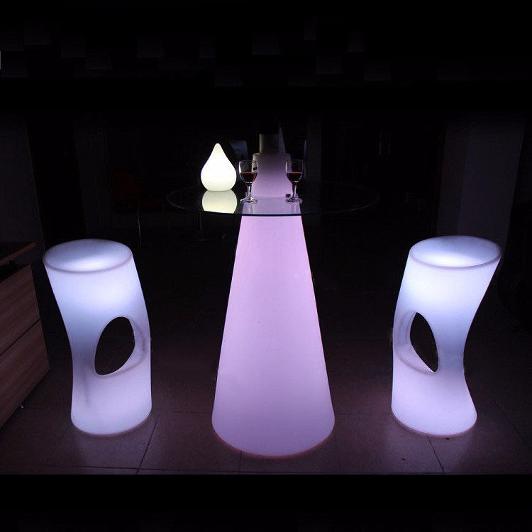 Kolorowe lampy LED oświetlają stoły koktajlowe do imprezy